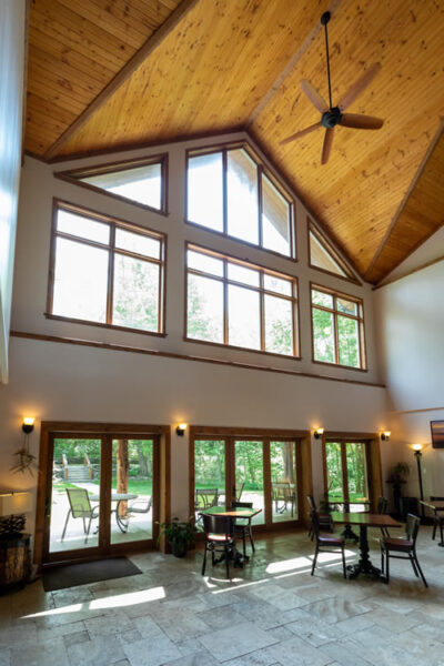 about the inn - interior with high ceiling and windows to forest